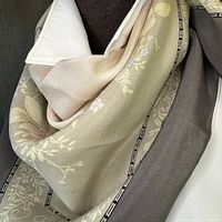 Close-up of scarf showing floral pattern in pale green and pink with grey border and silk texture.