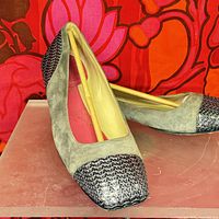 Pair of grey suede and sequin square toe flats. One shoe positioned upright showing overall shape, materials, and shine on the sequined toe caps.