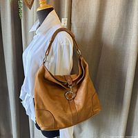 Full view of hobo bag on mannequin showcasing shape and color