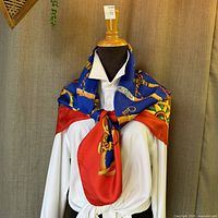 Scarf draped on mannequin showing multicolor walking stick and cane motif with red border