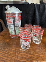 Full view of the cocktail mixer and the five glasses with rooster and text design