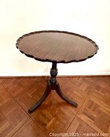 Full view of the vintage Brandt piecrust table showing the round mahogany top and spider leg base.