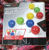 Box showing Rec-Tek Backyard Bocce Ball set with 8 colored bocce balls and 1 white pallino ball, 90 mm and 40 mm diameter respectively.