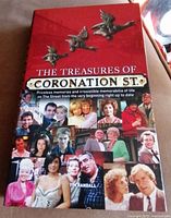 Front cover of the hardcover book titled 'The Treasures of Coronation Street' featuring images of cast members and decorative birds.