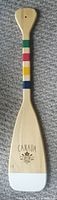 Full view of wooden canoe paddle with Hudson's Bay colored stripes and white painted blade tip.
