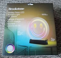 Box front showing Brookstone branding, smiley face LED light image with color changing LEDs, USB powered, and LED features.