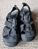 Front angle of black and grey men's sandals showing toe area, straps, and footbed.