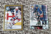 Front of two Wayne Gretzky hockey cards showing Gretzky in New York Rangers uniform, one traditional photo card and one holographic card.
