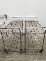 Two ventilated wire metal utility carts side by side showing full length and handles