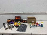 Lot overview showing Master Locks with keys, gloves, cable ties, Gorilla Tape, and lubricants on table.