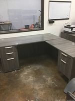 Full view of L shaped desk showing Newport gray wood grain finish and dual drawer sets on each side
