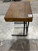 Full side view showing the wood top with grain, metal frame base, and table height.