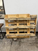 Front view of one wooden pallet showing structural slats and wear.