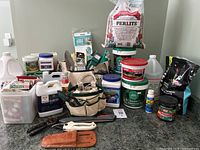 Overview of lot showing perlite bag, fertilizer buckets, soil bag, potting soil, jug, seed bin, tools and accessories