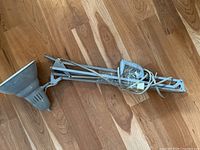 Full view of the folded adjustable metal desk lamp with grey shade and attached cord.