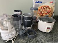 Full lot overview showing all appliances and original pizza stone box clustered on counter