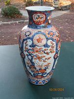 Front view of the hand painted Japanese Imari porcelain vase showing floral and nature motifs, medallions, and cobalt blue highlights.