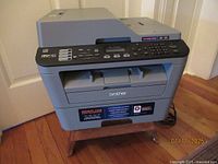 Front view of Brother multifunction printer showing control panel and paper output tray.