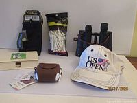 Overview of all items included in the golf accessories lot, showing gloves, tees, binoculars, pouch, cap, and lacquerware box.