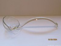 Side view of the glass punch ladle showing rounded bowl and curved handle