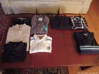 All eight collared shirts laid out on a surface showing folded and arranged shirts in various colors and patterns including polos and button-ups.