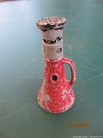 Front view of the red cast iron Simplex mechanical screw jack showing wear and toothed top lifting gear.