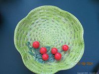 Green ceramic basket weave bowl with red cherry decoration, bottom marked 'Made in Japan'