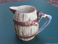 Front side view of vintage Twin Winton ceramic pitcher resembling a barrel with hillbilly handle