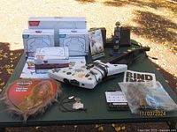Photo of all items laid out on a green surface including boxes, controllers, advertisement, and bindings