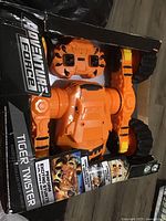 Front view photo of the Adventure Force Tiger Twister remote control truck in original packaging showing the orange and black toy vehicle and remote control.