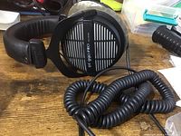 Front view of the headphones showing left ear cup grille, model and impedance branding.