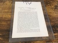 Full view of Civil War proclamation document in protective sleeve on wooden surface.