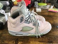 Side profile of the left shoe showing pink nubuck material, grey tongue, and translucent mesh panel.