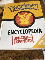 Cover of Pokémon Encyclopedia book with Pikachu on front and official product marking