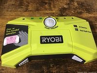 Front view of the Ryobi stud detector showing the brand label, center indication dial, and operational instructions.