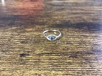 Front view of the sterling silver ring on wood surface showing size and stones.