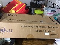 Closed box labeled Wali articulating single monitor desk mount Model M001XL designed for 13" to 27" monitors.