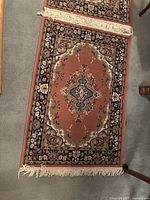 Two fringed Persian rugs laid on floor showing detailed floral and medallion patterns, demonstrating condition and size