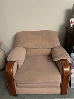 Front view of a beige cushioned loveseat chair with wooden curved armrests showing overall condition and design.