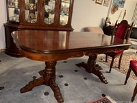 Side view of the vintage wood dining table showing polished top, rounded edges, and side carvings.
