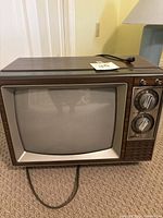 Front view of 15-inch RCA XL-100 TV showing CRT screen and woodgrain finish.