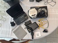 Full lot overview including Dynex DVD player, Kenwood CD player with box, Garmin GPS, yellow earbuds, cassette adapter, and power cables.