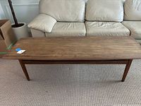 Front view of rectangular coffee table with tapered legs in living room setting