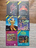 Group shot showing six books laid out in two columns and a set of metal miniatures below them