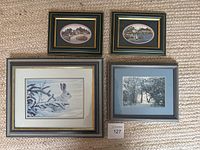 Four framed prints arranged on carpet, showing two small oval prints and two larger rectangular prints