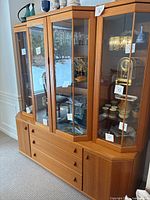Full view of mid-century modern china cabinet assembled, showing four glass display doors and lower drawers.