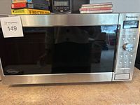 Front view of Panasonic microwave showing stainless steel door, control panel with knob and buttons, and label 149.