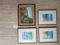 Five framed tropical and coastal themed pictures laid out on a carpeted floor, showing a variety of scenes including outdoor gathering and beach landscapes.