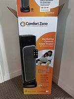 Photo of the Comfort Zone Oscillating Ceramic Tower Heater with packaging showing product details and remote control