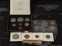 1975 uncirculated set coins displayed in original Royal Canadian Mint box; loose coins and others in plastic holders; 1963 penny roll visible